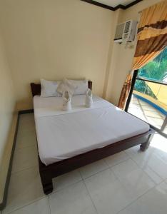 a bedroom with a bed with two mugs on it at Casimero Pension House in Boracay