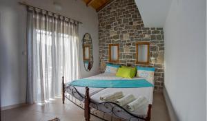 una camera da letto con un letto con un muro di pietra di Theano Apartments a Sárti