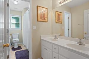 a bathroom with a sink and a toilet and a mirror at Great Family Home Near Stone Mountain Pk Sleeps 10 in Conyers +24 photos