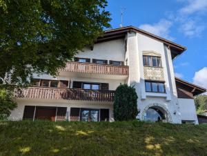a building with a balcony on top of a hill at Ferienwohnung am Almberg in Philippsreut
