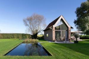 a small house with a pond in the yard at Dream house in Poperinge