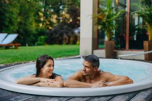mężczyzna i kobieta siedzący w wannie z hydromasażem w obiekcie Cottonina Hotel & Mineral SPA Resort w Świeradowie Zdroju