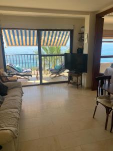 a living room with a television and a view of the ocean at La Traiña in Adra