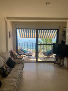 a living room with a couch and a view of the ocean at La Traiña in Adra +2 photos