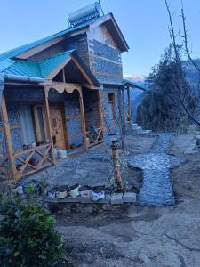 a small house with a staircase in front of it at Hunting Wood Kathkuni Attic Cottage in Mandi
