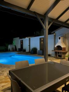 un patio con tavolo e sedie e una piscina di Villa spacieuse avec piscine à Saint-Pierre a Saint-Pierre