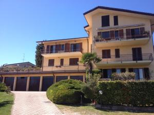 a large apartment building with a balcony and bushes at Casa Sole Appartement con terrazzo in Bardolino