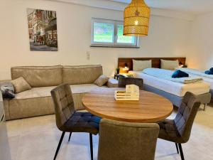 a living room with a table and a couch at JUNIPRO Apartments Haustadt in Beckingen