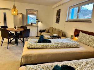 a living room with two beds and a table at JUNIPRO Apartments Haustadt in Beckingen