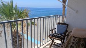 a chair sitting on a balcony overlooking the ocean at La Traiña in Adra