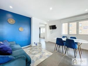 een woonkamer met een bank en een tafel bij La Marée - Appt à 50m de la plage in Bray-Dunes