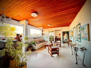 a large living room with a wooden ceiling at Pousada Divina Vila in Ilha de Boipeba