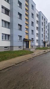 an empty street in front of a building at Apartamentai Naujojoje Akmenėje in Naujoji Akmenė