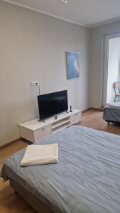 a bedroom with a bed and a tv on a dresser at Apartamentai Naujojoje Akmenėje in Naujoji Akmenė