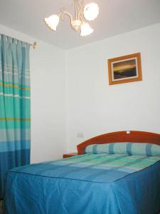 a bedroom with a bed with a blue comforter at Apartamentos Egeivan in Pontón Alto