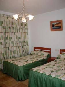 - une chambre avec 2 lits et un lustre dans l'établissement Apartamentos Egeivan, à Pontón Alto