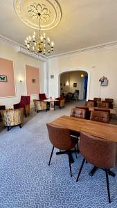 a large room with a table and chairs and a chandelier at Acacia Hotel in London