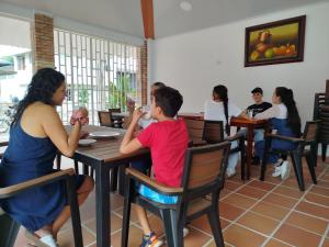 a group of people sitting at a table in a restaurant at Hotel Camino al Llano in Villavicencio