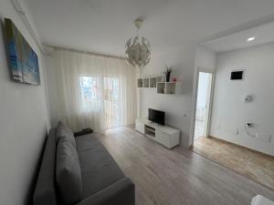 a living room with a couch and a television at Relax Apartment Militari Residence Sector 6 in Roşu