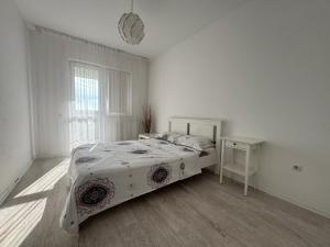 a white bedroom with a bed and a window at Relax Apartment Militari Residence Sector 6 in Roşu
