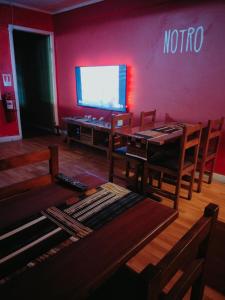 a living room with a tv and a table and chairs at Hostel Notro Valdivia in Valdivia