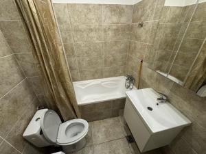 a bathroom with a toilet and a tub and a sink at Relax Apartment Militari Residence Sector 6 in Roşu +8 photos