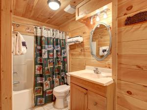Un baño con lavabo, inodoro y espejo. en Game room, hot tub, flat easy drive to 3BR cabin!, en Sevierville 20 fotos más