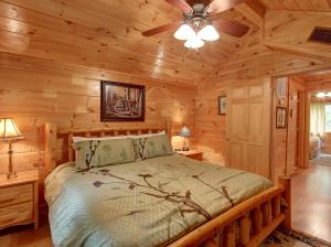Un dormitorio con una cama en una cabaña de troncos en Game room, hot tub, flat easy drive to 3BR cabin!, en Sevierville