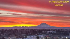 een zonsondergang boven een stad met een berg op de achtergrond bij Double room-wake up to stunning sunrises, unwind magical sunsets in Tacoma
