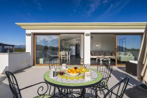 a table with a bowl of fruit on a patio at Lighthouse Holiday Home in Àrbatax