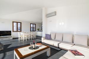 a living room with a couch and a table at Lighthouse Holiday Home in Àrbatax
