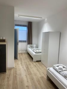 a white room with two beds and a window at Goldstar Hotel Hannover in Hannover