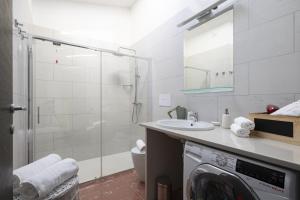 a bathroom with a shower and a washing machine at Lighthouse Holiday Home in Àrbatax +32 photos