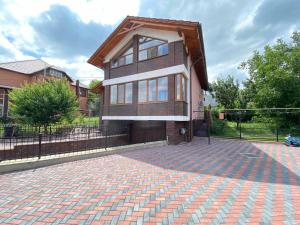 a house with a brick driveway in front of a fence at Дом для отпуска in Codru