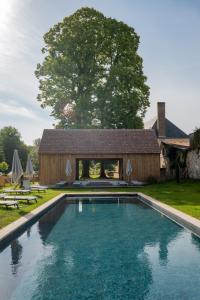 a swimming pool in front of a house at Hôtel les Prés in Saint-Hilaire-le-Châtel