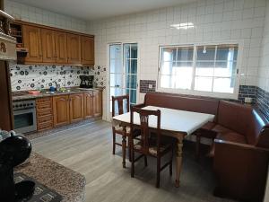kuchnia z drewnianymi szafkami, stołem i krzesłami w obiekcie Apartamento Shenzhen en Astorga Camino de Santiago Cochera bicis w mieście Astorga