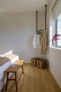 a bedroom with a bed and a bench and a window at Acropolis Penthouse Plunge Pool in Athens
