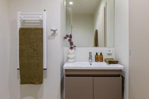 a white bathroom with a sink and a mirror at Acropolis Penthouse Plunge Pool in Athens +38 photos