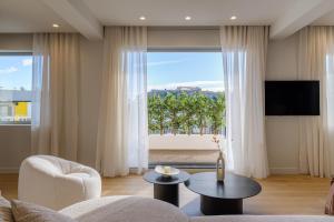 a living room with a couch and a large window at Acropolis Penthouse Plunge Pool in Athens