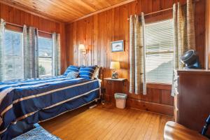 a bedroom with wooden walls and a bed and a window at KD2043- The Gray House in Kill Devil Hills