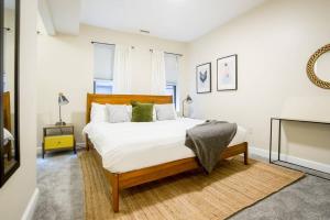 ボストンにあるPerfect North End Apt 2BR 2BA Laundryのベッドルーム1室(白いシーツと緑の枕が備わるベッド1台付)
