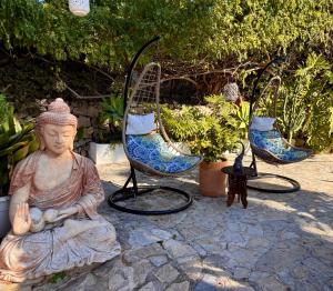 a statue of a buddha sitting on the ground with plants at Hotel Altea Paradise 1917 - Adults Only in Altea