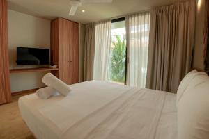 a bedroom with a large white bed and a window at Unnu in Santa Cruz Huatulco