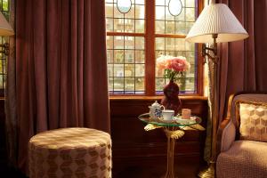 a room with a table with a vase of flowers and a window at Hotel Estheréa in Amsterdam