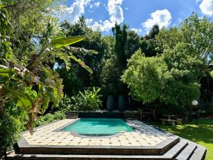 a swimming pool in the middle of a garden at Pass-through Apartments in Pretoria