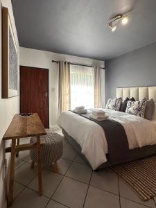 a bedroom with a large bed and a window at Pass-through Apartments in Pretoria +13 photos