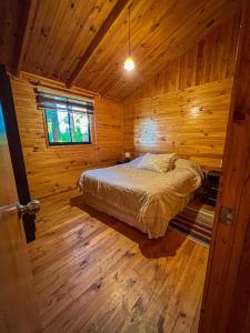 a bedroom with a bed in a wooden cabin at Cabañas Ruta Del Lago in Puerto Varas +37 photos
