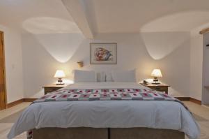 a bedroom with a large white bed with two lamps at Resort Fazenda 3 Pinheiros in Engenheiro Passos