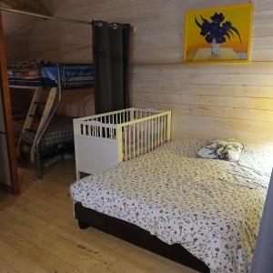 a bed in a room with a wooden wall at Le Chouette loft in Boudou +25 photos