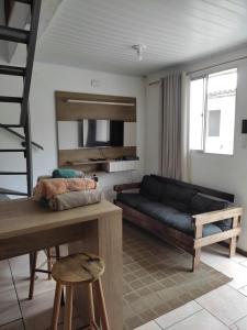a living room with a black couch in a room at Pousada Brum in Pelotas